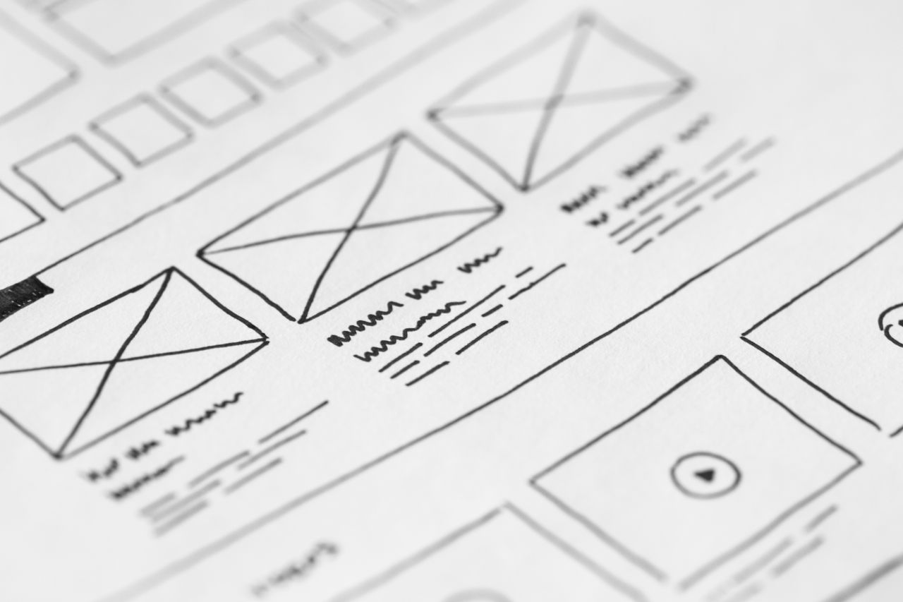 services-02 Detailed close-up of a hand-drawn wireframe design on paper for a UX project.